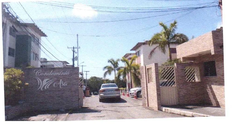 Apartamento branco em condomínio Asa com entrada e portaria em área urbana com carros estacionados