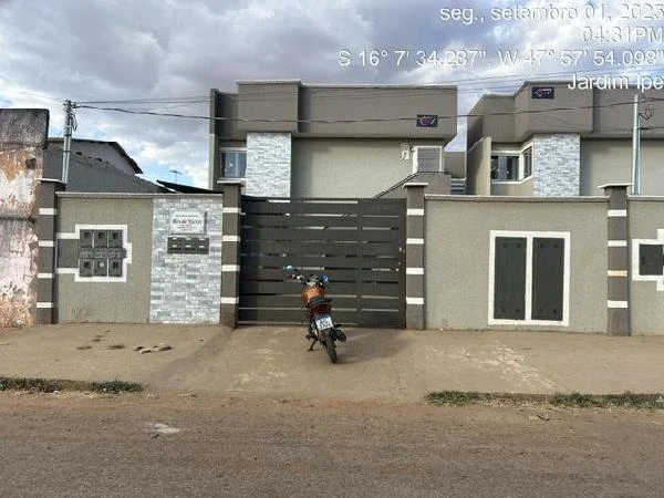 Apartamento cinza em condomínio residencial com fachada moderna e moto estacionada na entrada