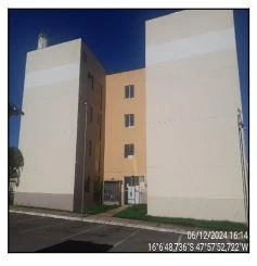 Apartamento em condomínio com fachada branca e entrada de acesso