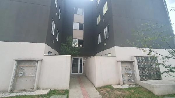 Apartamento cinza em condomínio residencial com entrada principal e janelas visíveis fachada sem avarias
