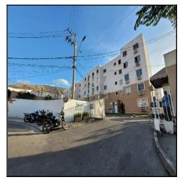 Apartamento branco em condomínio residencial completo com várias janelas e motos estacionadas na entrada