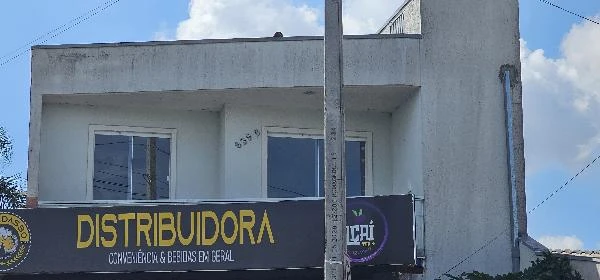 Apartamento branco de 78m² com janelas amplas em prédio comercial com distribuidora no térreo em área urbana