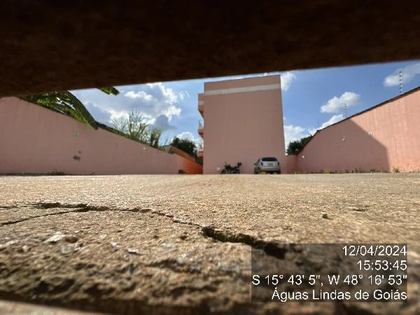 Apartamento rosa em condomínio fechado com duas vagas próximas e área externa com parede rosa céu azul ao fundo