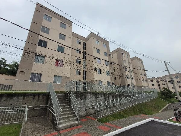 Apartamento bege com janelas brancas em condomínio residencial com área externa e rampas de acesso