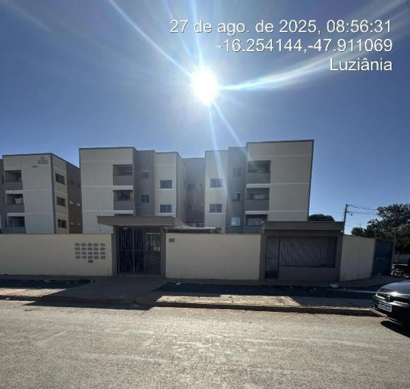 Apartamento branco em condomínio residencial de três andares com portão e garagem em Luziânia