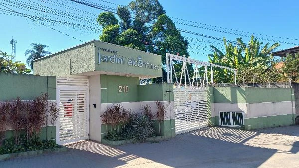 Apartamento em condomínio com portão de entrada e fachada de tom verde