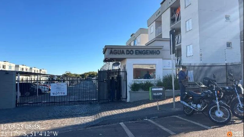 Apartamento branco de 2 quartos em condomínio com guarita e grade preta na entrada em área urbana