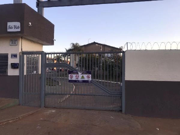 Entrada do Condomínio Residencial Bela Vista com portão metálico e grades de segurança cercados por muros pintados