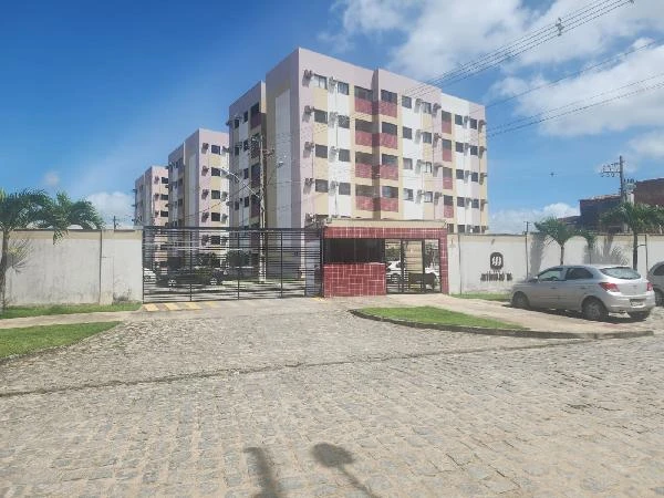 Apartamento branco e bege de 5 andares no Condomínio Residencial Antonio Rocha com portão de entrada e carros estacionados