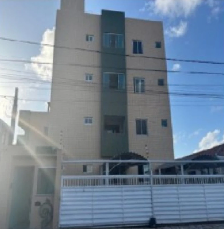 Apartamento em prédio de quatro andares com fachada clara e detalhes em verde localizado na Rua Penha Emília Silva em área urbana