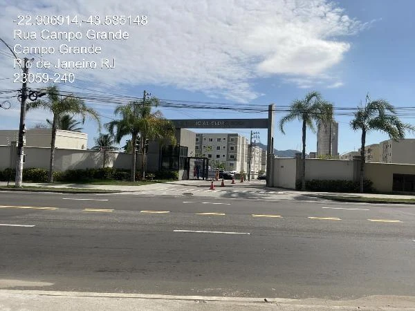 Apartamento branco de 41 metros quadrados em condomínio residencial com portaria e palmeiras na entrada