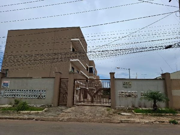 Apartamento bege em condomínio residencial com portão metálico e fachada sem avarias visíveis em área urbana