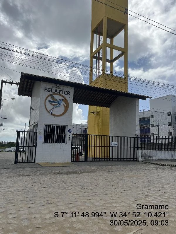 Apartamento em condomínio residencial com portaria e torre amarela em área externa pavimentada no Gramame