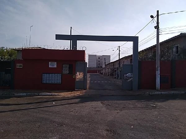 Apartamento com portaria e entrada em condomínio residencial com muros vermelhos e guarita de segurança