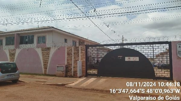 Apartamento visível em condomínio com portão de entrada e área comum