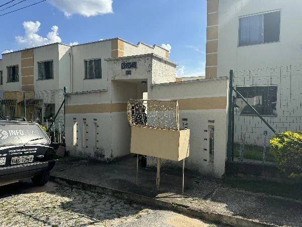 Apartamento branco de 2 andares com cerca baixa e vaga na garagem próximo a calçada em área residencial