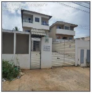 Apartamento de fachada branca com portão metálico em área residencial, estrutura em bom estado