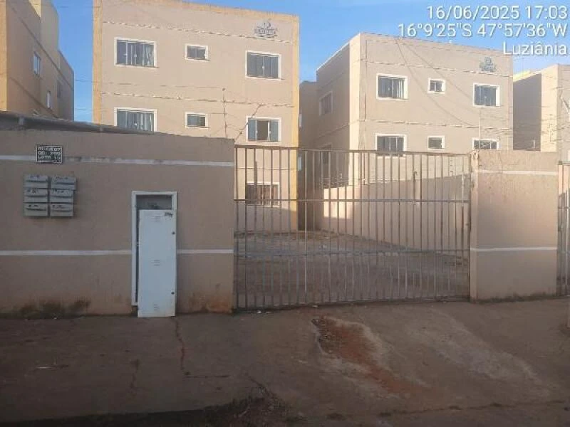 Apartamento bege em condomínio com portão metálico e muro baixo em área urbana de Luziania