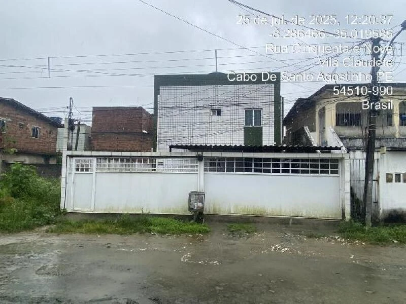 Apartamento branco com grades na fachada localizado em rua pavimentada no Cabo de Santo Agostinho com algumas áreas com mofo e parede desgastada