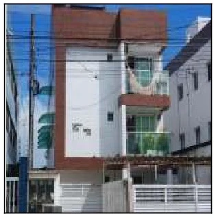 Apartamento branco com detalhes em marrom, sacada com vidro verde, localizado em área urbana com cercas e fios elétricos