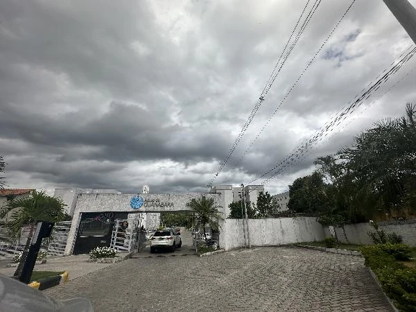 Apartamento branco 43m² no Condomínio Residencial Águas de Guanabara com entrada principal e área externa com árvores