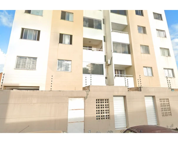 Apartamento branco com sacada, localizado em prédio de múltiplos andares, fachada com grades de segurança e cerca elétrica