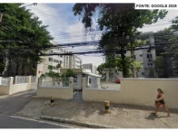 Apartamento branco com muro baixo e guarita em área urbana, fachada sem avarias visíveis