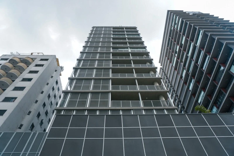 Apartamento não residencial com fachada moderna em vidro e metal situado na Rua Frei Caneca cercado por prédios próximos