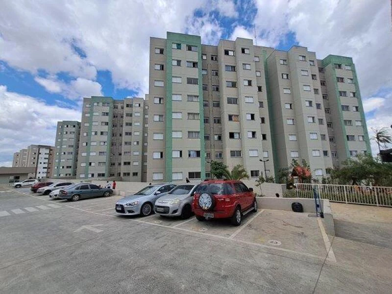 Apartamento cinza claro no Condomínio Residencial Itaqua IA com várias janelas e estacionamento externo com carros
