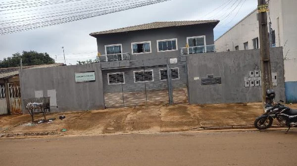 Apartamento cinza em condomínio com portão metálico e fachada moderna visto de frente em área urbana