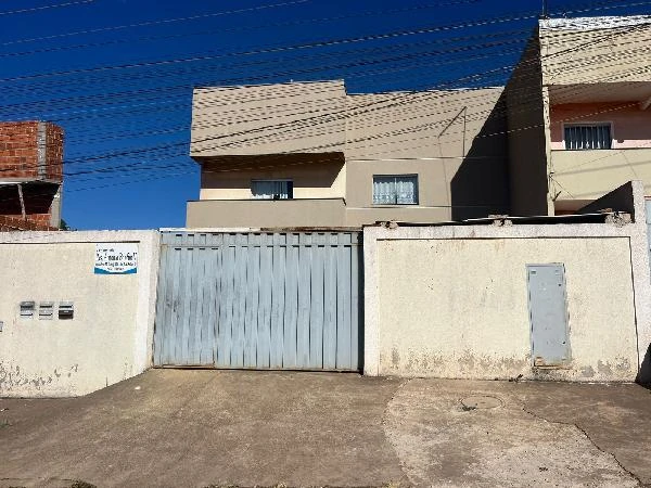 Apartamento bege em condomínio fechado com portão metálico azul e fachada simples em área urbana