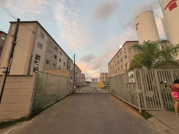 Apartamento bege em condomínio fechado com portão de ferro e prédios de quatro andares em área urbana