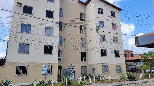 Apartamento em condomínio residencial com fachada clara e portas de aço