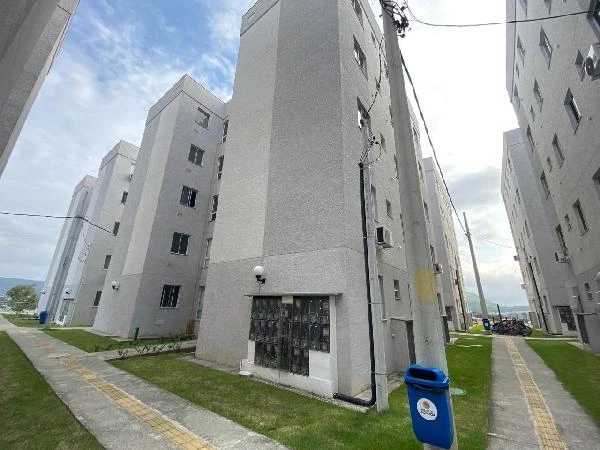 Apartamento cinza em condomínio residencial com múltiplos blocos de 5 andares e área externa gramada