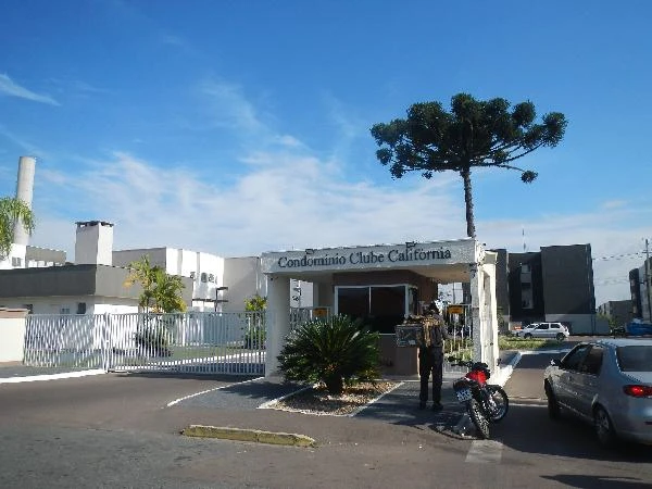 Apartamento no Condomínio Clube California com portaria, cenário ensolarado, com carros e motocicleta no acesso