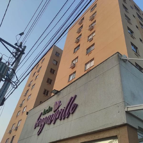 Apartamento em torre residencial com fachada amarela e sinalização de Jardim Bouganville