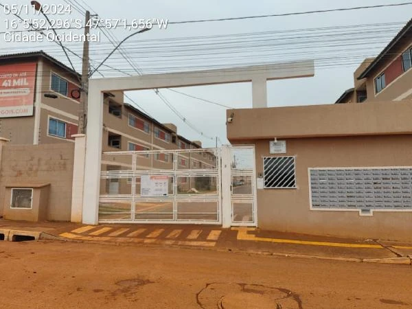 Apartamento do condomínio residencial Alvorada III com portão branco de metal e fachada com blocos de caixas de correio na entrada principal