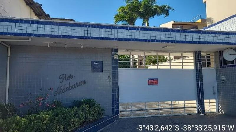 Apartamento branco de 86 metros quadrados no Residencial Aldebaran com portão cinza e fachada com azulejos azuis