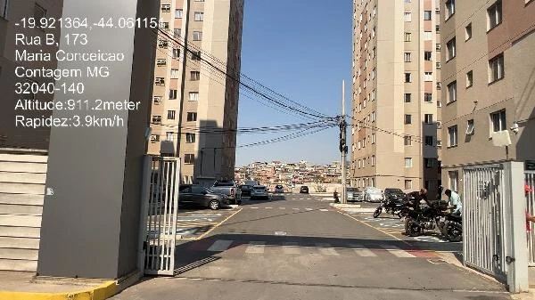 Apartamento com fachada de edifícios altos em condomínio com faixa de pedestres e veículos estacionados no pátio interno
