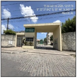 Entrada principal com guarita e portão de condomínio residencial em área urbana com céu claro