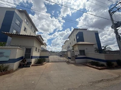 Apartamento branco e azul em condomínio residencial com portão eletrônico e vagas de garagem visíveis