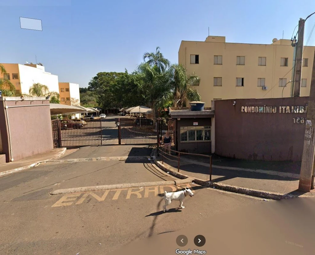 Apartamento de fachada amarela e muro marrom no condomínio Itajubá com portão de entrada cerrado em Ribeirão Preto