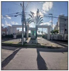 Apartamento com entrada de condomínio e palmeiras na frente