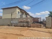 Apartamento bege com 2 quartos em condomínio com muro e portão de ferro em área urbana