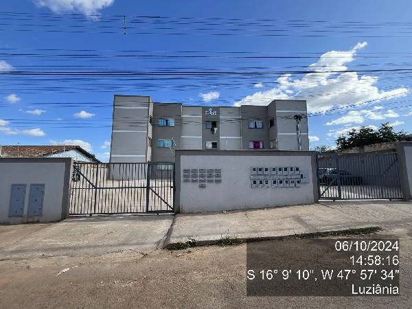 Apartamento cinza em condomínio fechado com portões de metal e área externa pavimentada em Luziania