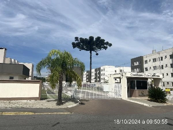 Apartamento branco com portão automático e guarita no Condomínio Residencial California em área urbana