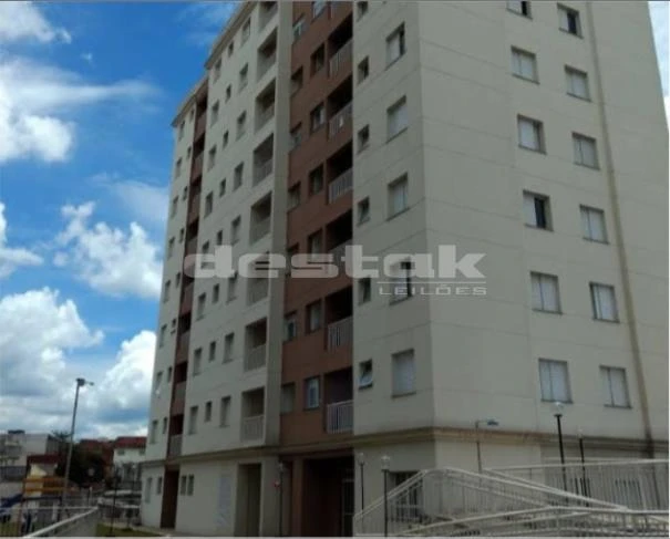 Apartamento branco de 5 andares com sacadas e janelas em prédio residencial em área urbana sob céu parcialmente nublado