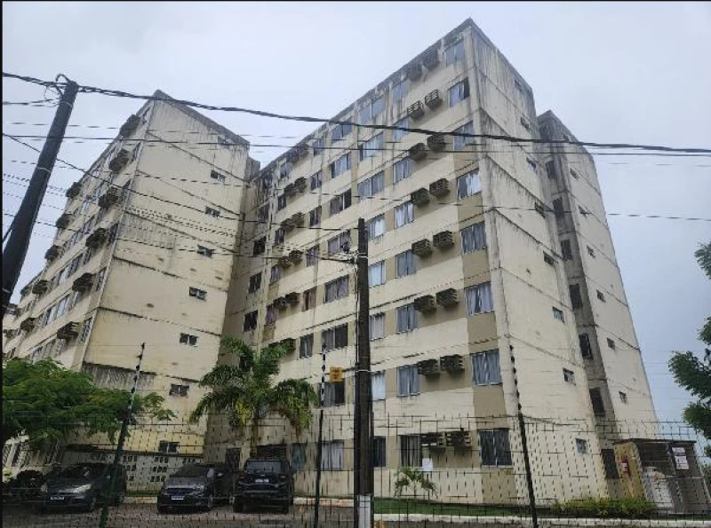 Apartamento bege de 8 andares com vários aparelhos de ar condicionado na fachada em área urbana cercada