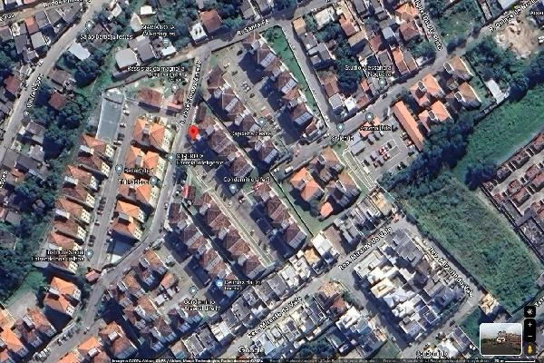 Vista aérea do condomínio residencial com prédios de apartamentos próximos a área verde e ruas pavimentadas