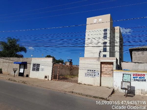 Apartamento branco com 5 andares em condomínio fechado com muro e portão na rua